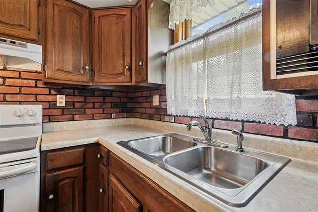 a kitchen with kitchen island granite countertop a sink and a window