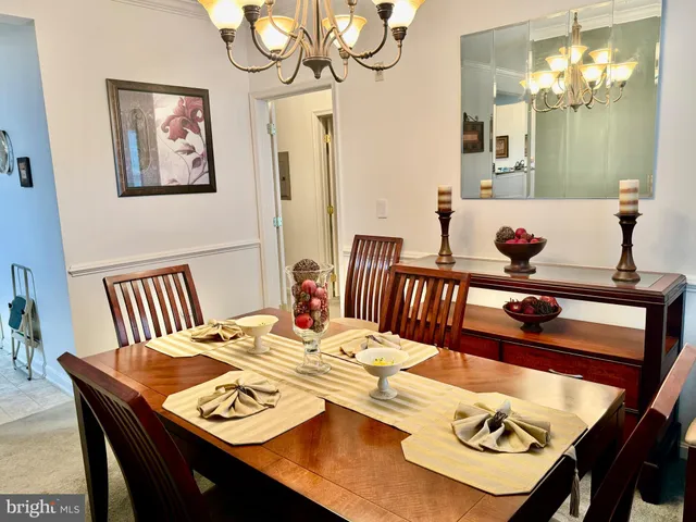 a view of a dining room with furniture a chandelier and wooden floor
