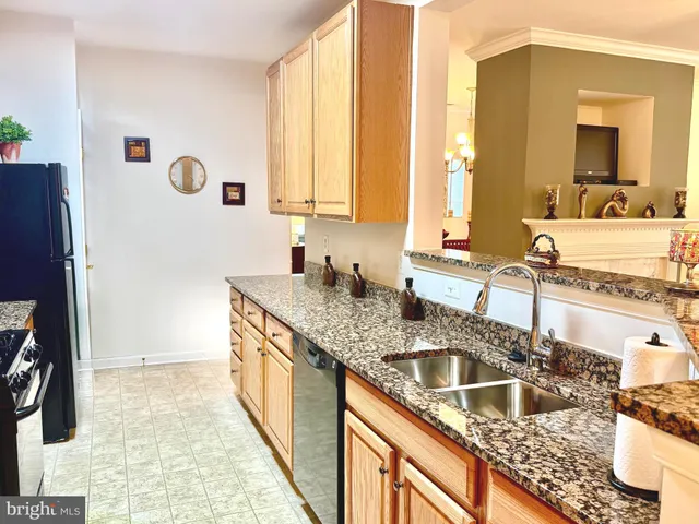 a kitchen with granite countertop a sink a counter top space and cabinets