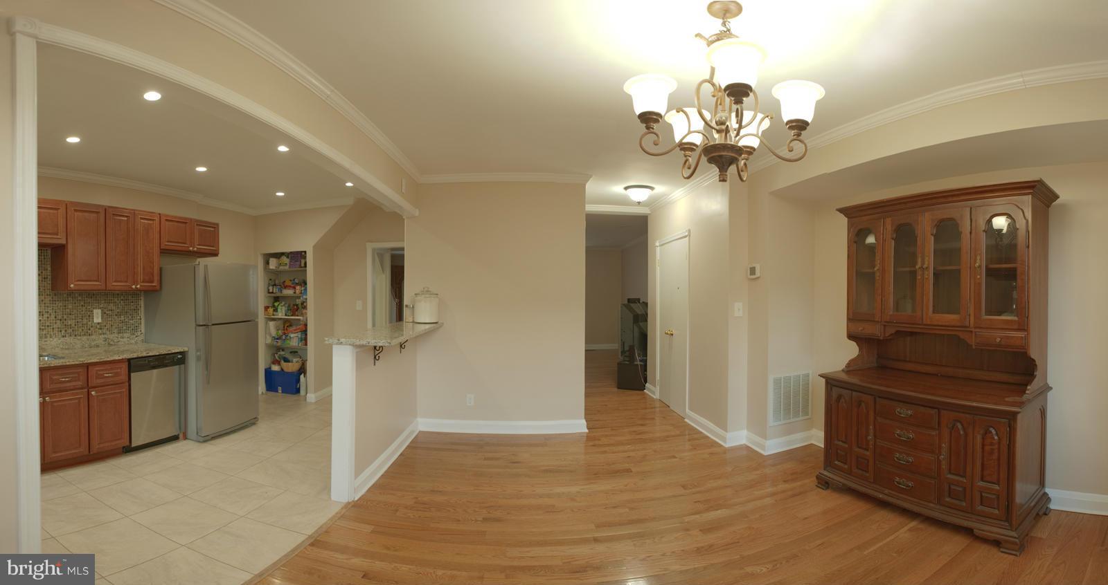 1536 Kingsway Road Baltimore, MD 21218 - Photo 2 of 20 a view of a hallway with wooden floor and a kitchen