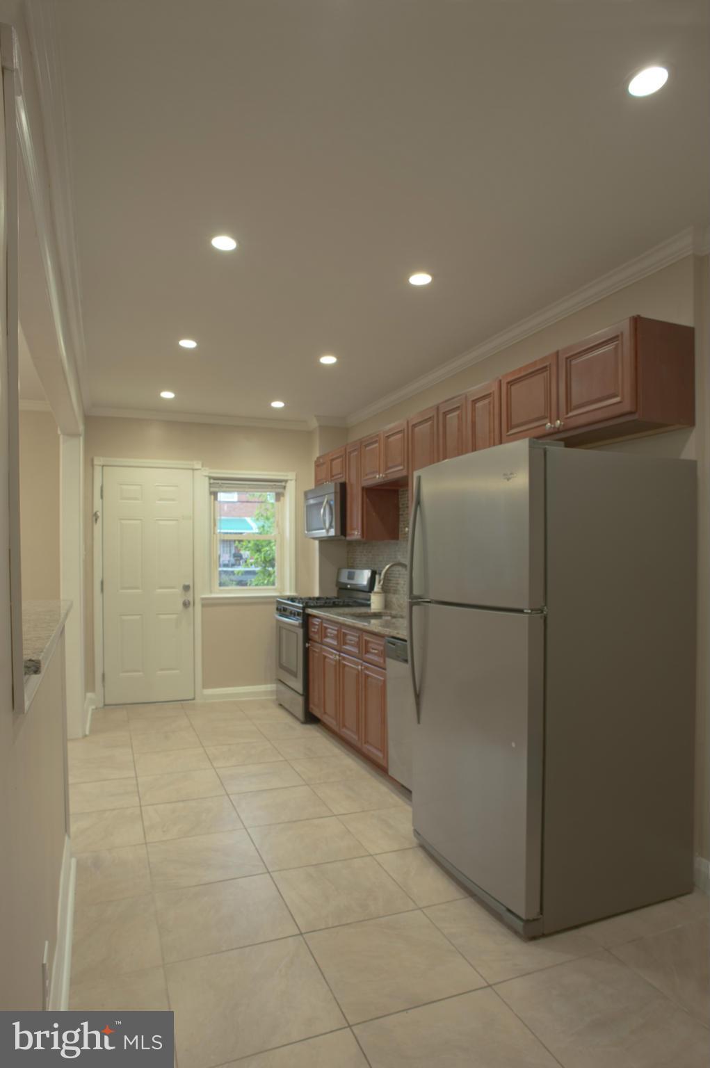 1536 Kingsway Road Baltimore, MD 21218 - Photo 3 of 20 a kitchen with a refrigerator and a sink