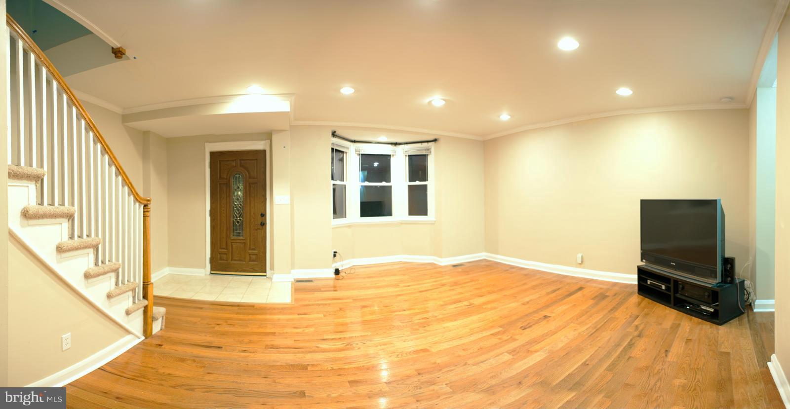 1536 Kingsway Road Baltimore, MD 21218 - Photo 4 of 20 a view of an empty room with wooden floor and a window
