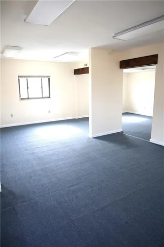 an empty room with a wooden floor and a window