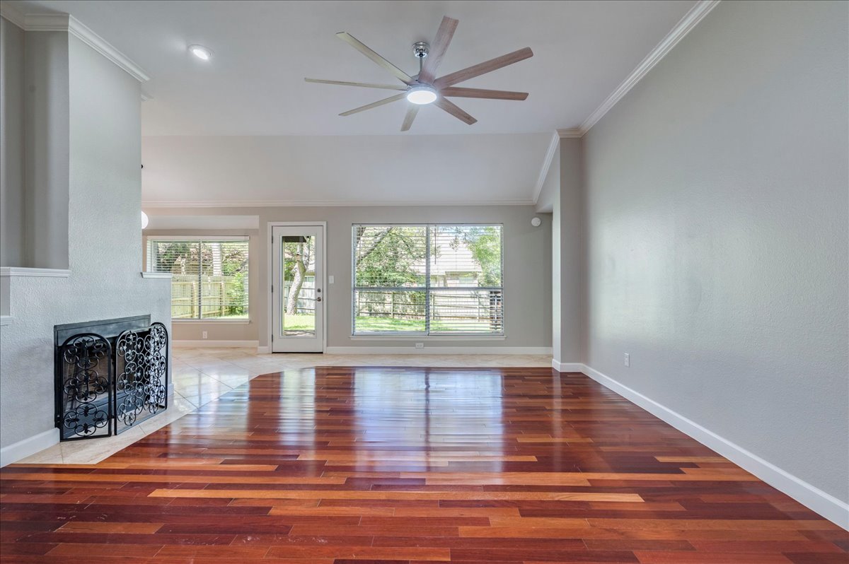 6530 Needham Lane Austin, TX 78739 - Photo 4 of 29 Lustrous hardwood floors and a cozy fireplace create an inviting atmosphere in this open-concept living space.