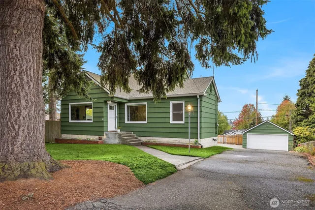a view of a house with a yard and tree