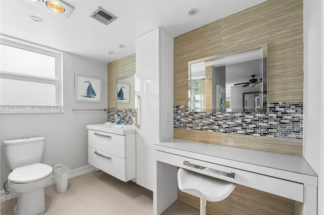 a bathroom with a sink a toilet and mirror