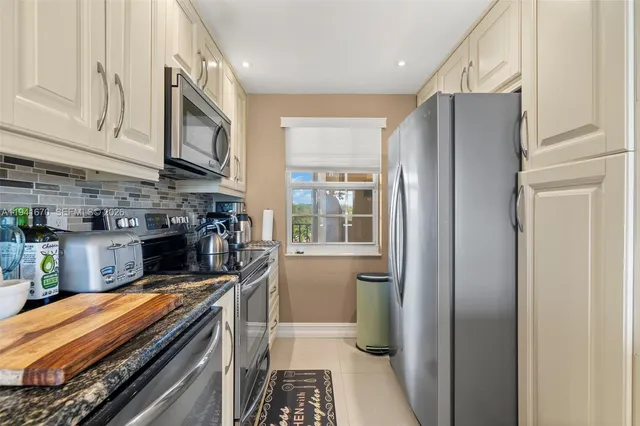 a kitchen with stainless steel appliances granite countertop a refrigerator and a stove