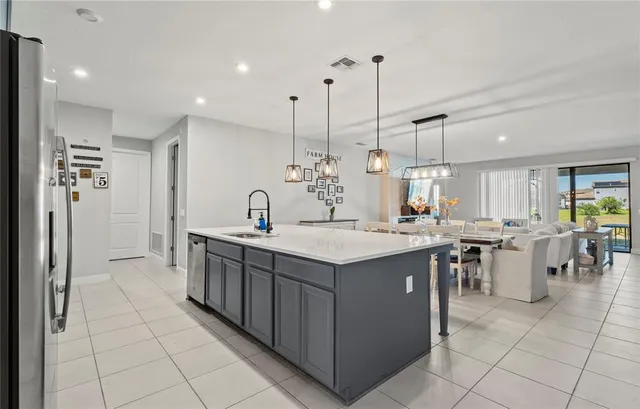 a large kitchen with stainless steel appliances kitchen island granite countertop a refrigerator a sink a stove and oven