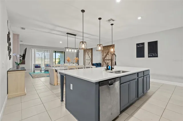 a kitchen with a sink a faucet a chandelier and living room view