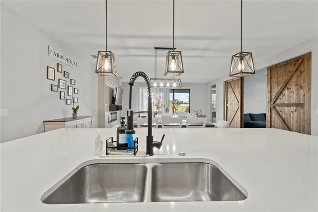 a kitchen with stainless steel appliances a table and chairs in it