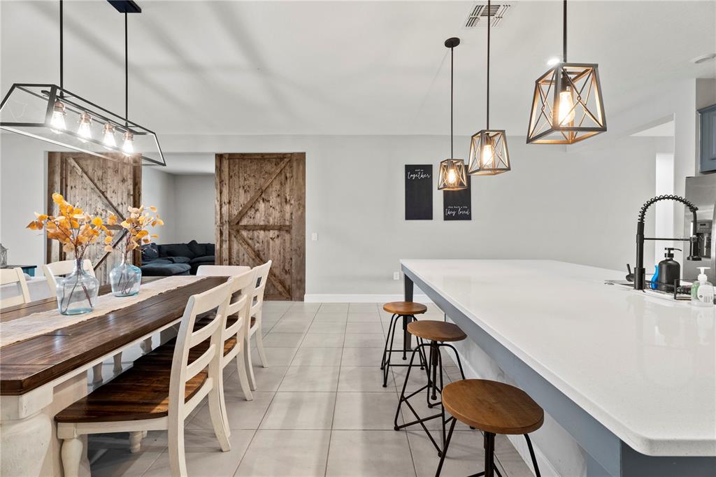 2731 Rialto Court Kissimmee, FL 34746 - Photo 16 of 49 a kitchen with stainless steel appliances a table and chairs in it