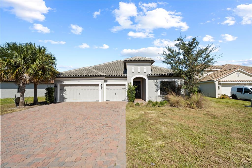 2731 Rialto Court Kissimmee, FL 34746 - Photo 2 of 49 a view of a house with a yard and garage