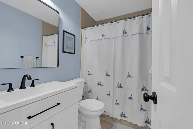 a bathroom with a sink a toilet and shower curtain