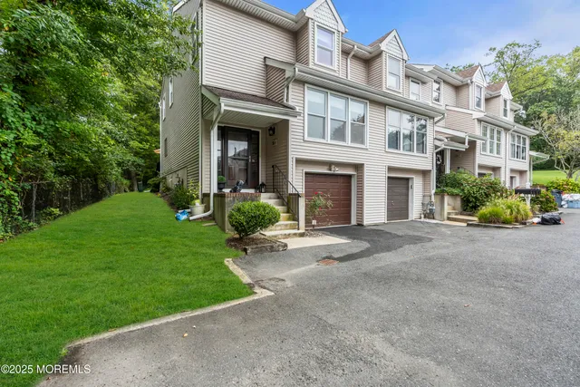 a front view of a house with a yard and trees