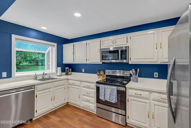 a kitchen with granite countertop white cabinets and white appliances