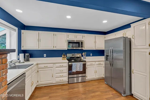 a kitchen with white cabinets and stainless steel appliances