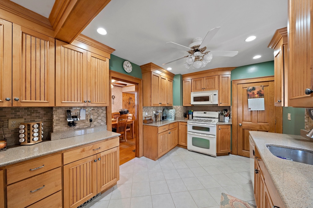 14 Vanness Road Weymouth, MA 02191 - Photo 9 of 27 a kitchen with stainless steel appliances granite countertop a stove top oven a sink dishwasher a dining table and chairs with wooden floor