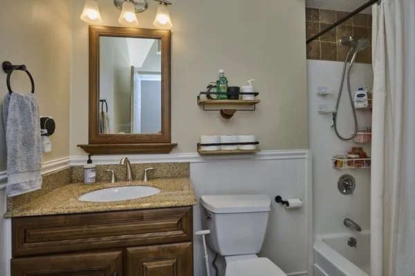 a bathroom with a granite countertop sink toilet and shower