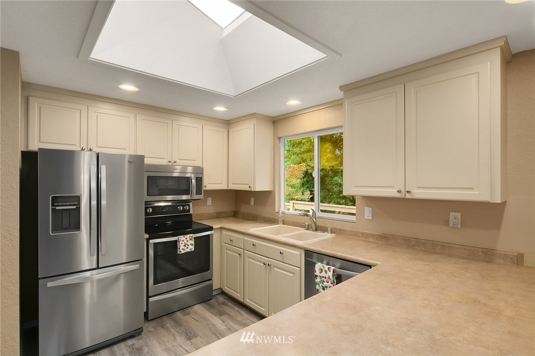 24022 7th Avenue West Bothell, WA 98021 - Photo 7 of 26 a kitchen with a refrigerator a sink and a stove top oven