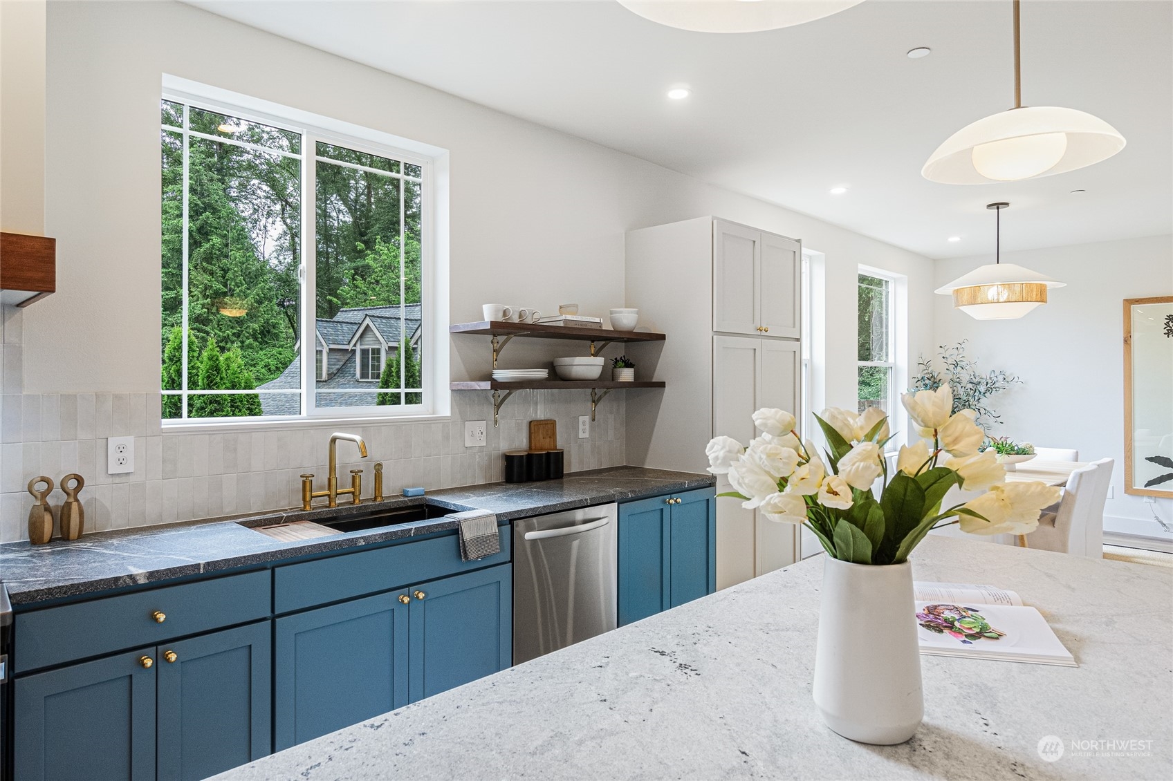 24310 13th Place West Bothell, WA 98021 - Photo 17 of 35 a kitchen with stainless steel appliances kitchen island granite countertop a sink a potted plant and a window