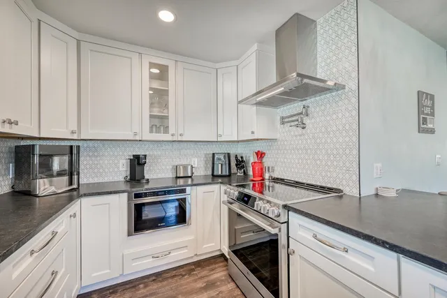 a kitchen with granite countertop a sink and a refrigerator