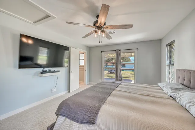 a bedroom with a large bed and a chandelier