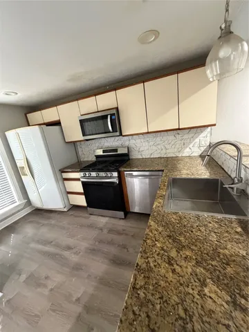 an empty room with wooden floor and fireplace