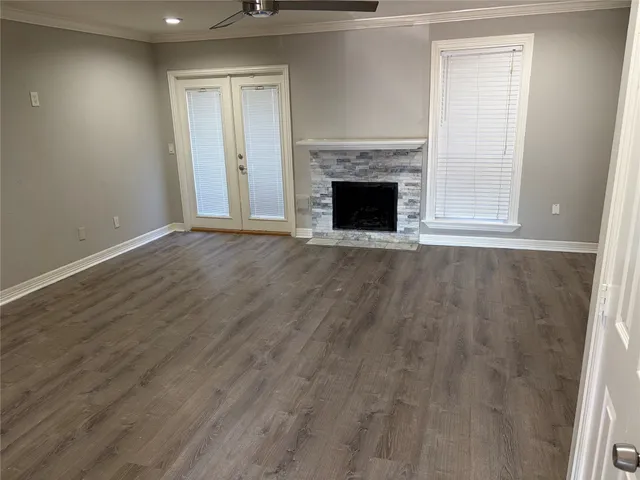 an empty room with wooden floor and fireplace