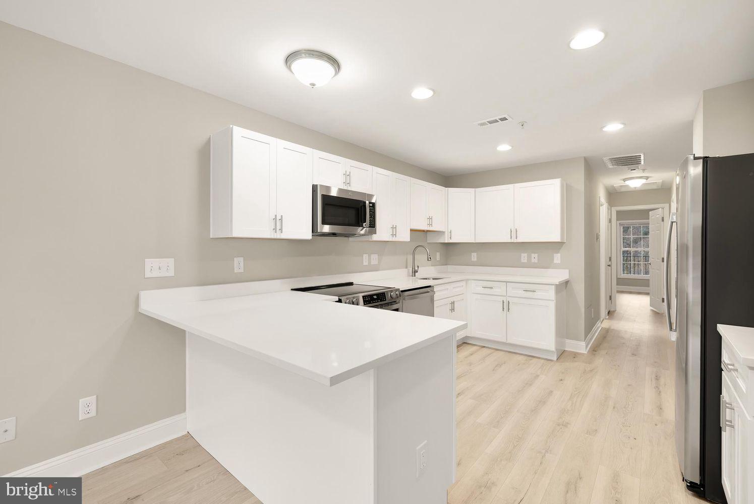 1753 W Street Southeast, Unit C Washington, DC 20020 - Photo 13 of 29 a kitchen with a sink a counter top space stainless steel appliances and cabinets