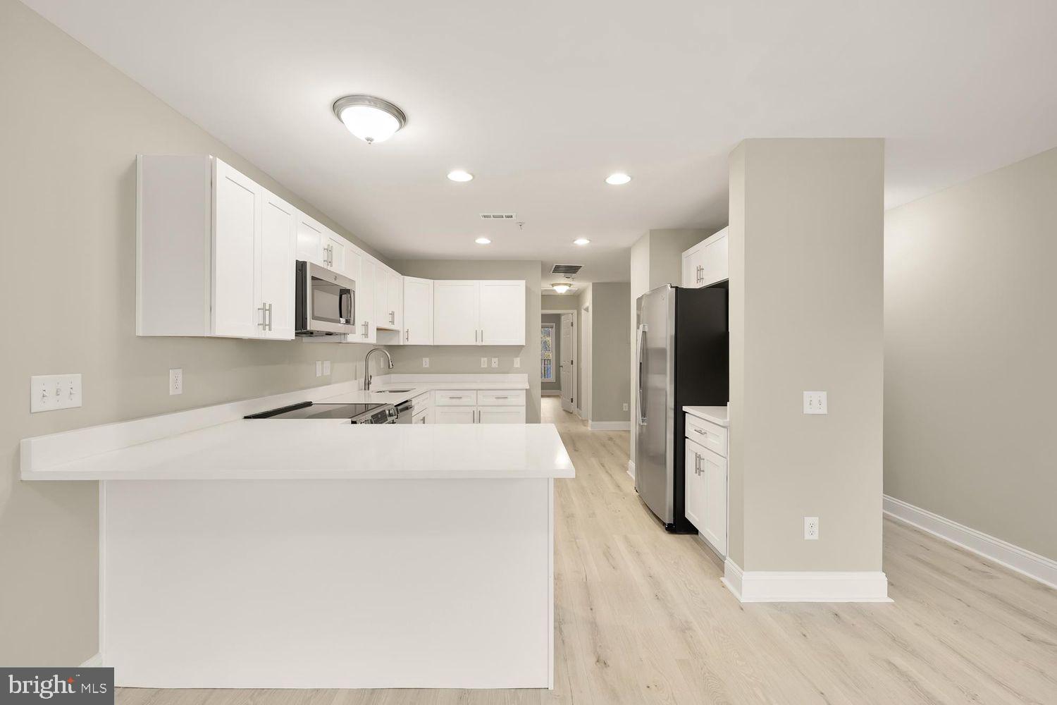 1753 W Street Southeast, Unit C Washington, DC 20020 - Photo 14 of 29 a kitchen with stainless steel appliances kitchen island a refrigerator sink and cabinets