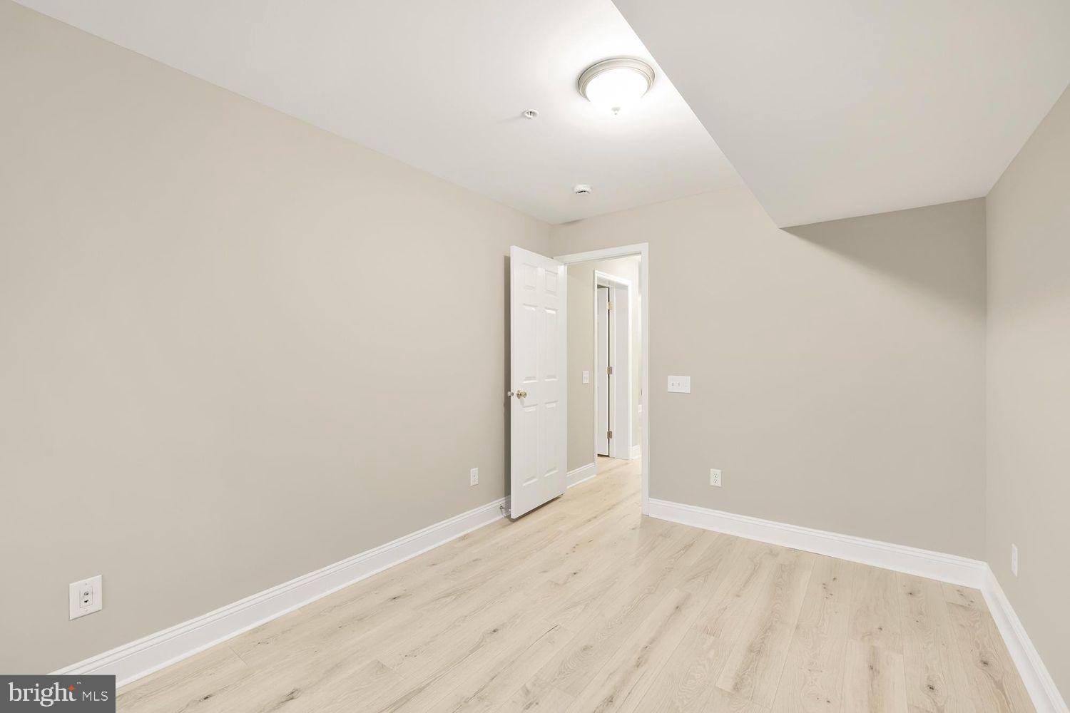 1753 W Street Southeast, Unit C Washington, DC 20020 - Photo 19 of 29 an empty room with wooden floor and windows