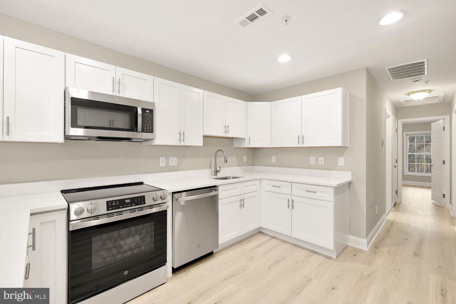 1753 W Street Southeast, Unit C Washington, DC 20020 - Photo 9 of 29 a kitchen with granite countertop white cabinets sink and stainless steel appliances