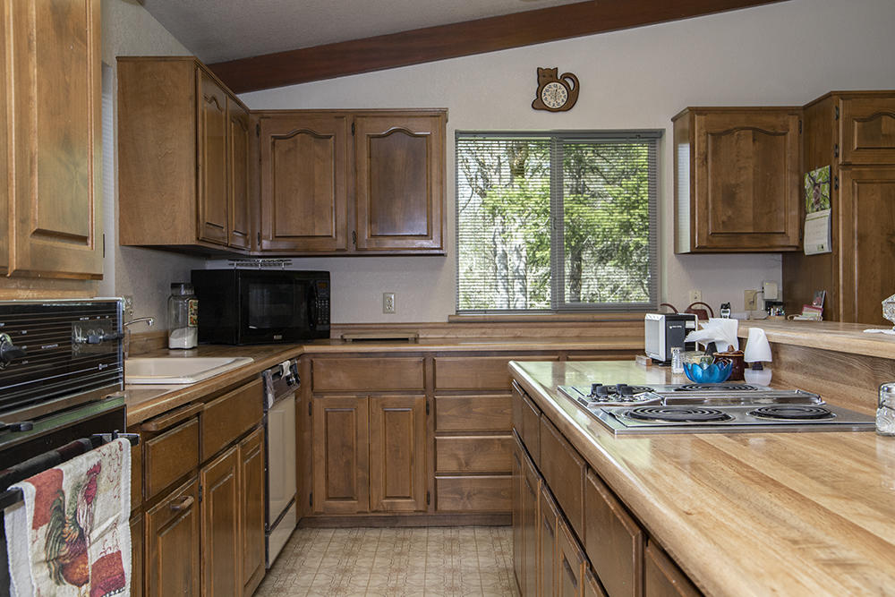 1735 Robertson Bridge Road Grants Pass, OR 97526 - Photo 8 of 47 a kitchen with kitchen island granite countertop a sink stove and cabinets