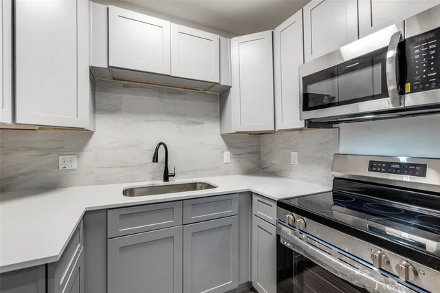 a kitchen with a sink stainless steel appliances and refrigerator