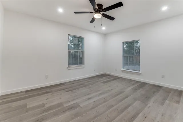 wooden floor in an empty room with a ceiling fan