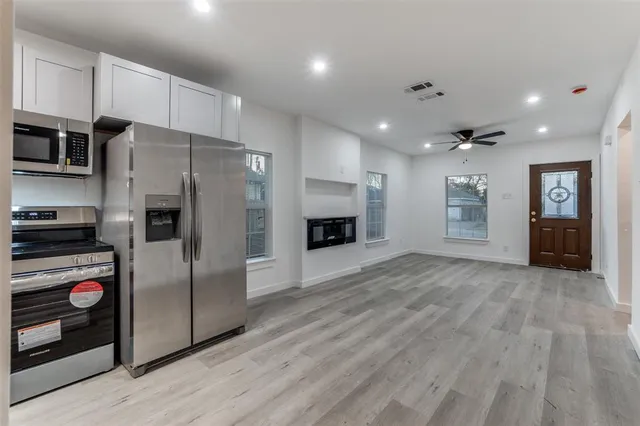 a kitchen with stainless steel appliances a refrigerator and a stove top oven