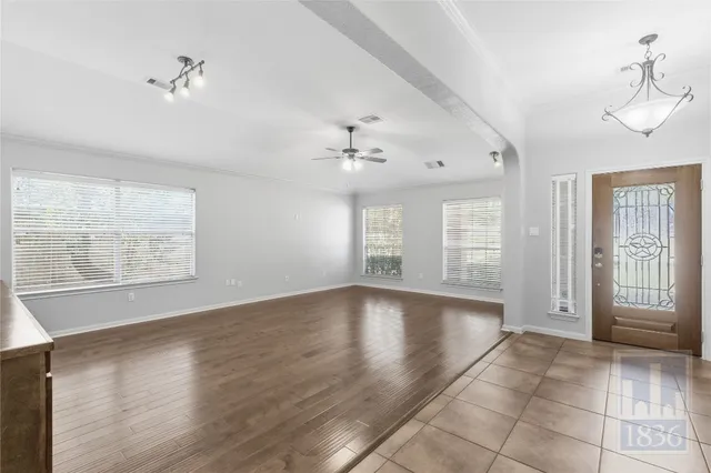 a view of an empty room with a window and wooden floor