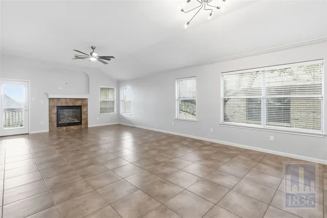 a view of an empty room with a window and fireplace