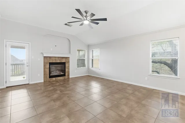 an empty room with windows and fireplace