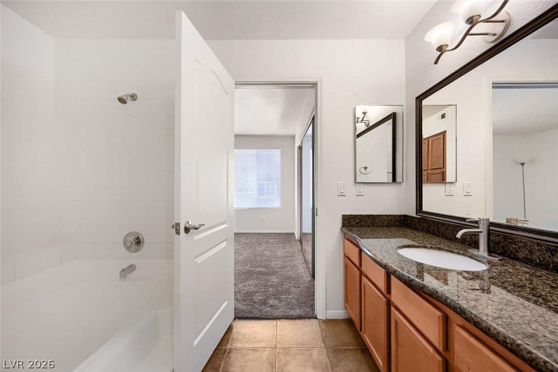 9325 West Desert Inn Road, Unit 177 Las Vegas, NV 89117 - Photo 20 of 24 A well-appointed bathroom offers a granite countertop vanity and a shower-over-tub combination.