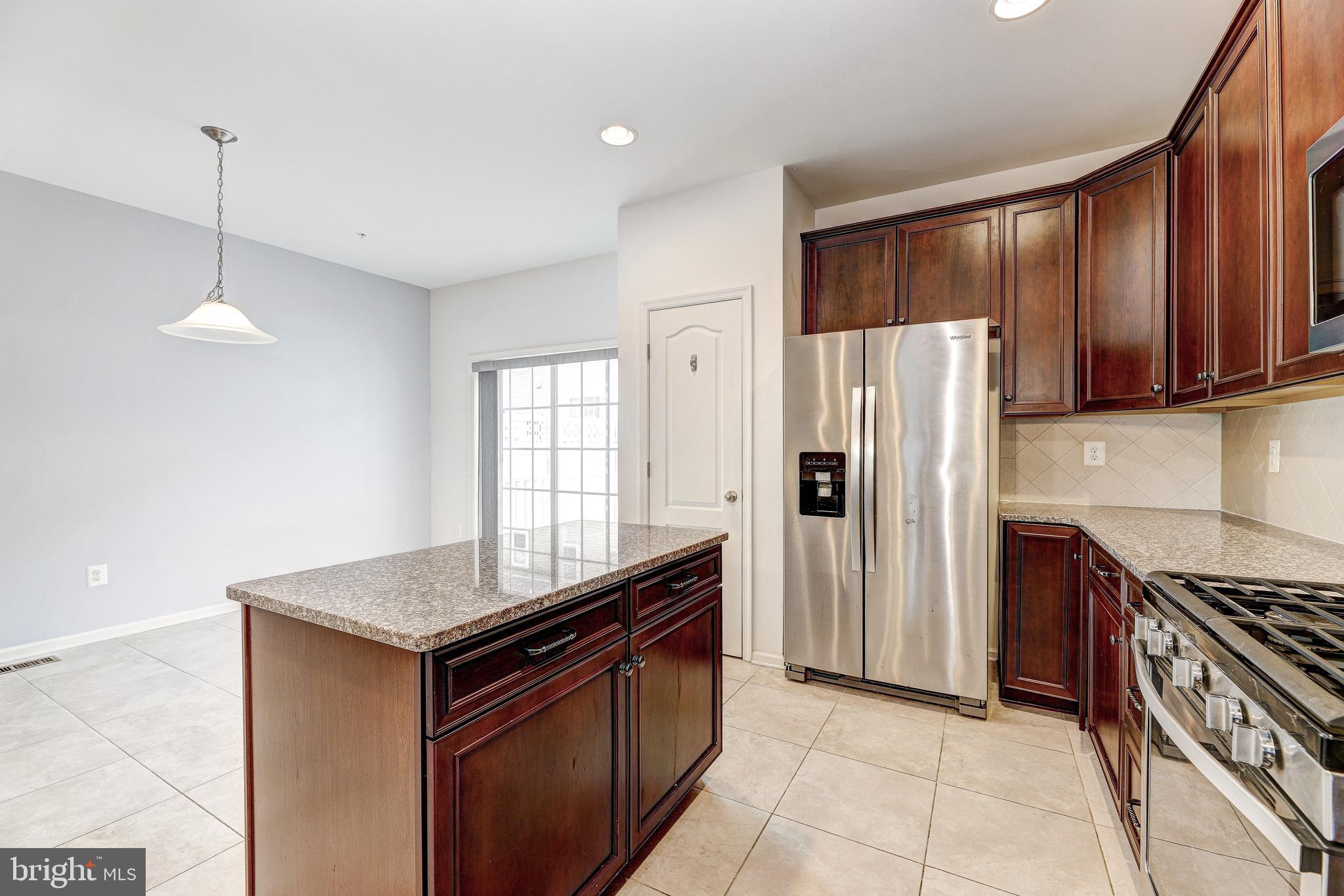 912 Winter Run Road Middle River, MD 21220 - Photo 14 of 55 a kitchen with stainless steel appliances granite countertop a refrigerator a sink and wooden cabinets