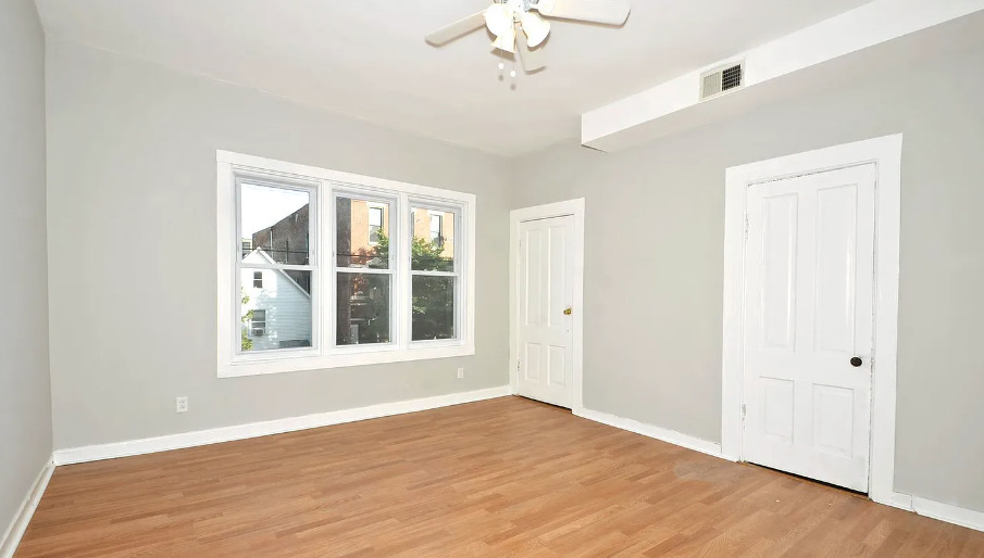 1838 South Racine Avenue Chicago, IL 60608 - Photo 13 of 16 a view of an empty room with wooden floor and a window