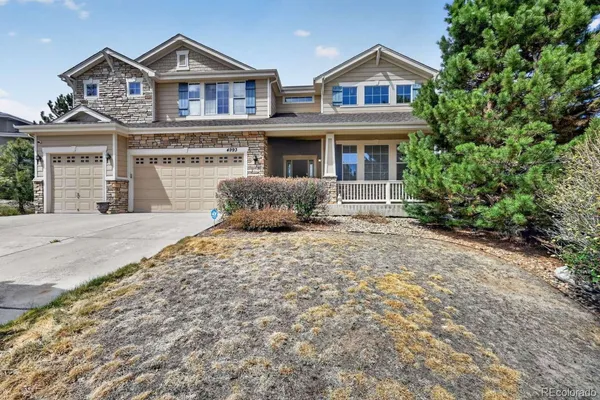 a front view of a house with yard and parking