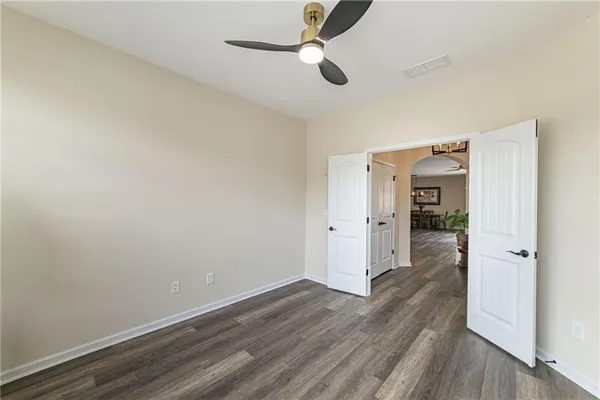 a view of an empty room with wooden floor fireplace and a window