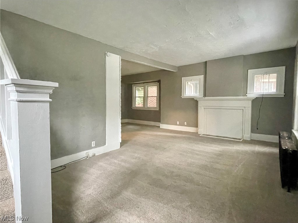 857 Aberdeen Street Akron, OH 44310 - Photo 2 of 23 Carpeted empty room with a textured ceiling, a fireplace, and plenty of natural light