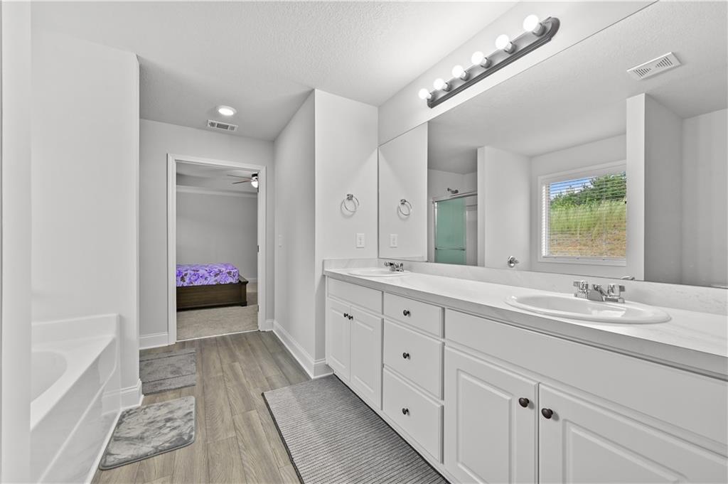 68 Suwannee Way Jefferson, GA 30549 - Photo 23 of 28 a spacious bathroom with a granite countertop sink a mirror and a bathtub