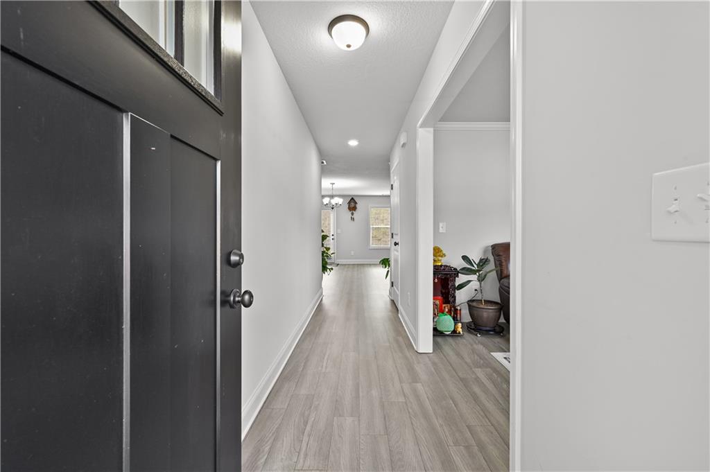 68 Suwannee Way Jefferson, GA 30549 - Photo 8 of 28 a view of a hallway with wooden floor and a living room