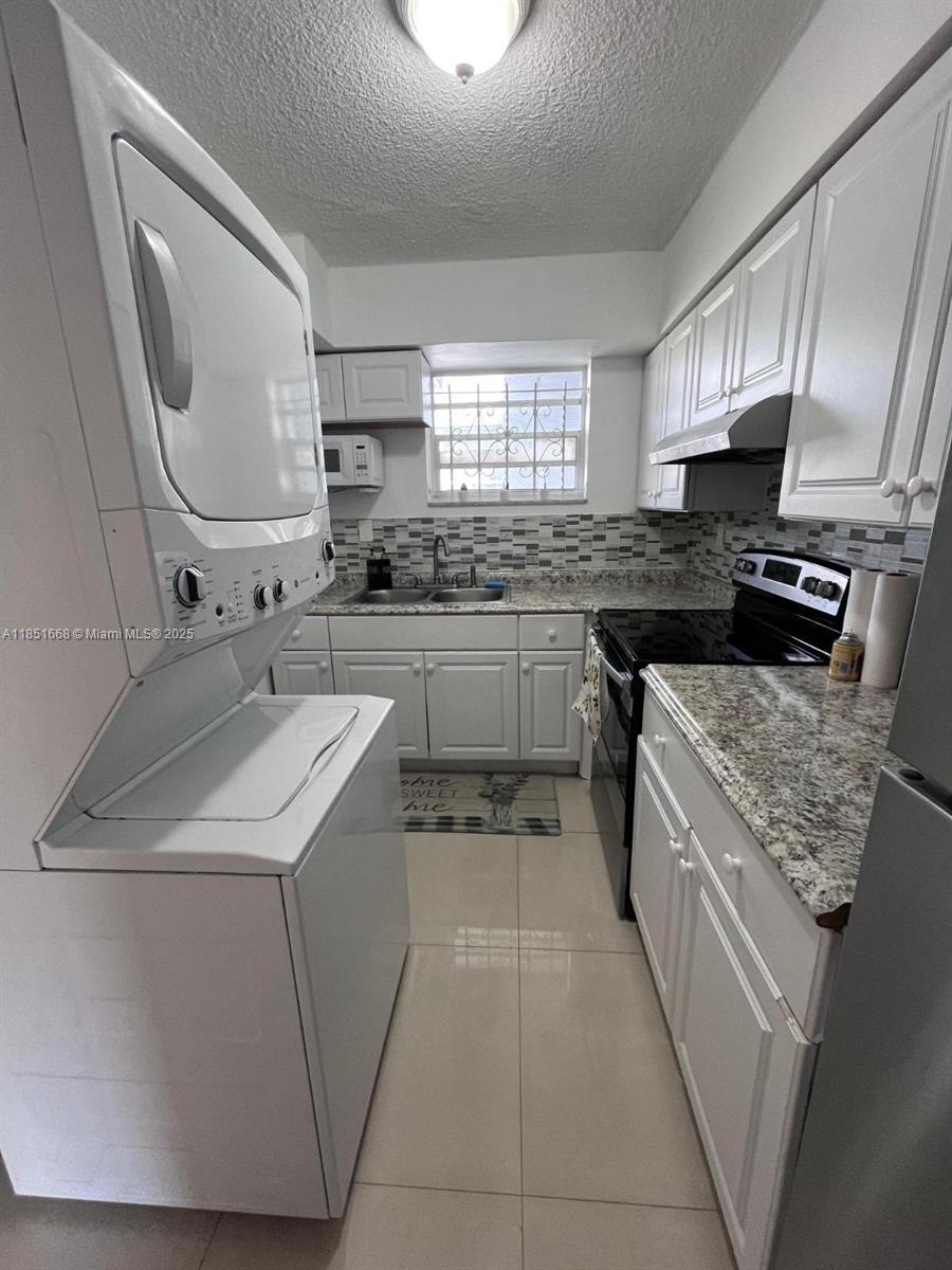 2496 Southwest 17th Avenue, Unit 5301 Miami, FL 33145 - Photo 13 of 19 a kitchen with a sink stove and cabinets