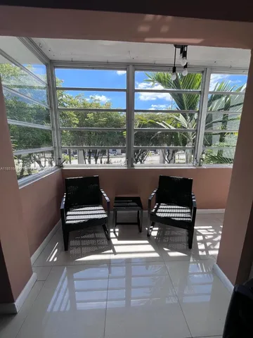 a living room with large windows and a table