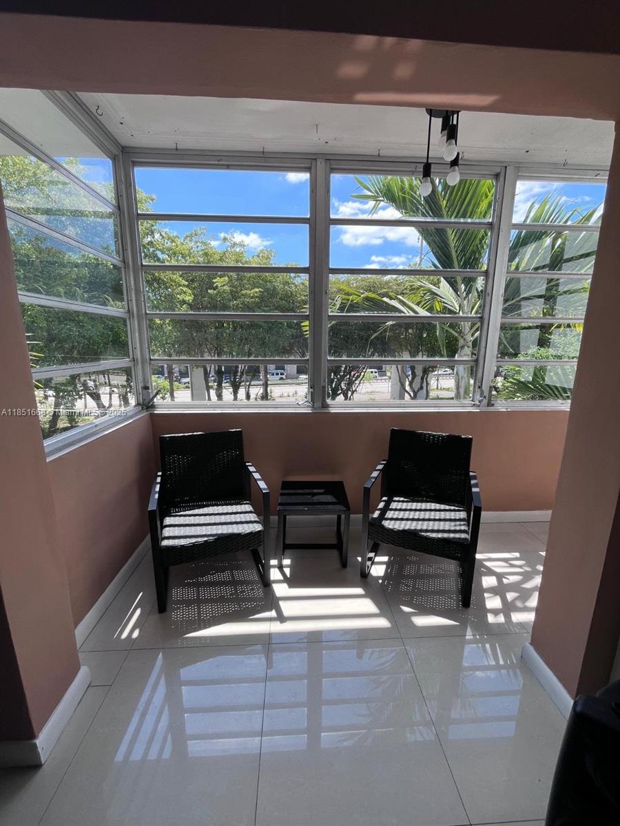 2496 Southwest 17th Avenue, Unit 5301 Miami, FL 33145 - Photo 15 of 19 a living room with large windows and a table